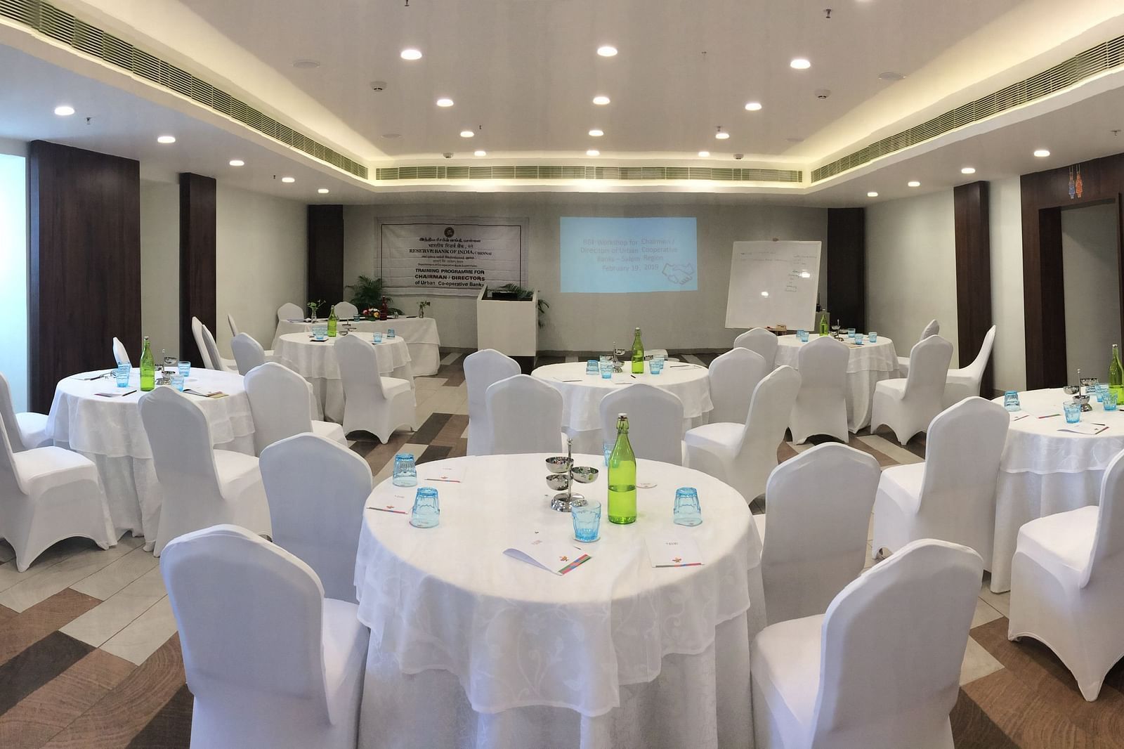 image of the event hall with round tables and chairs at  Zibe Salem by GRT Hotels