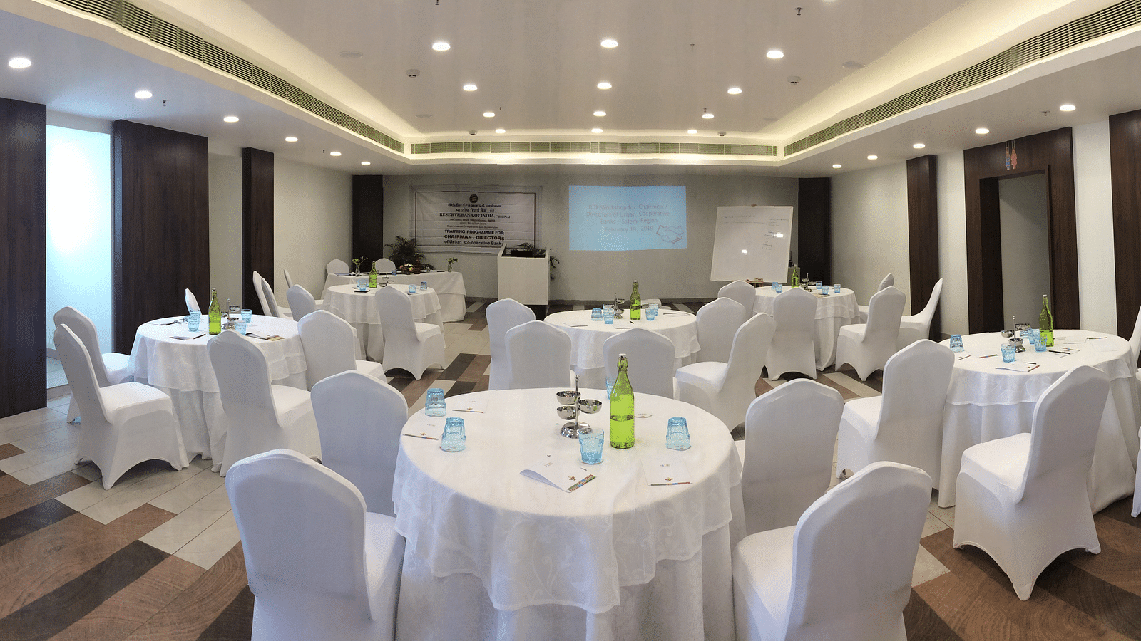 image of the event hall with round tables and chairs at  Zibe Salem by GRT Hotels