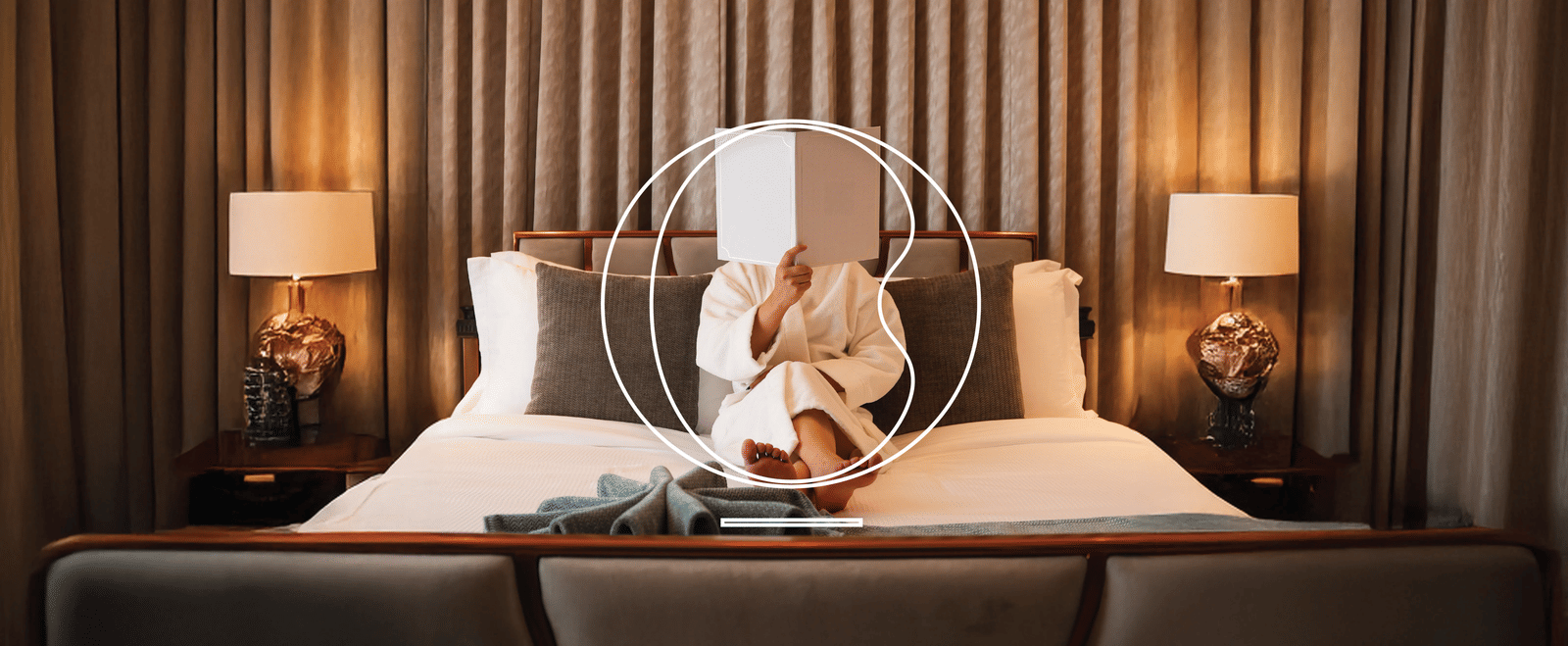 A person holding a menu in front of their face while sitting on the bed at one of the hotel rooms in North Goa at MIROS Hotels