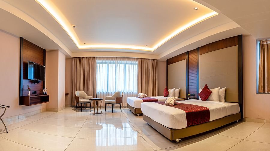 A panoramic view of a room featuring a bed, a seating area, and a television at M Pro Palace.