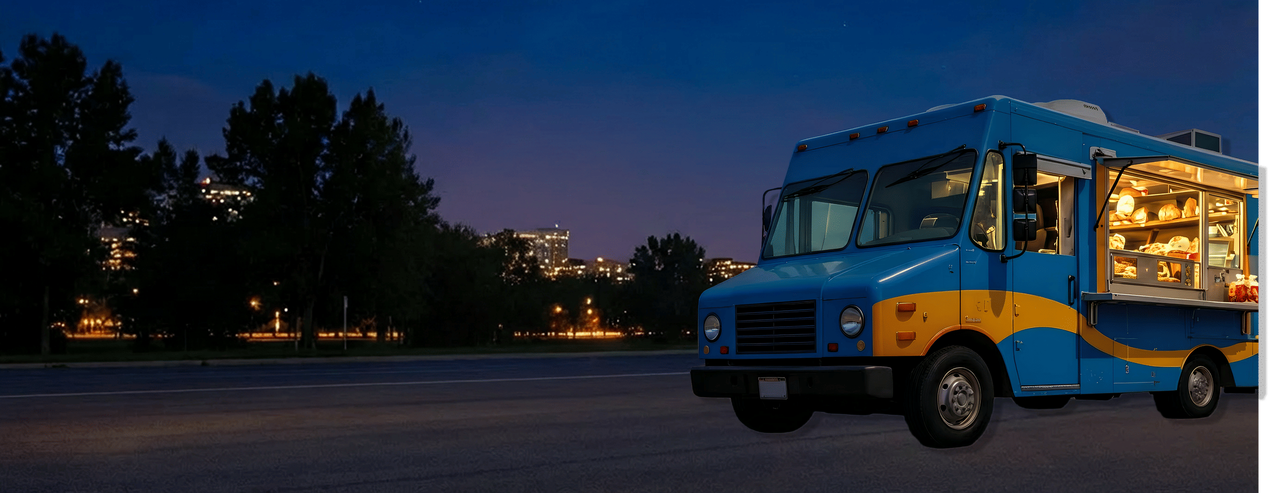 Brightly colored food truck parked on a road at night.
