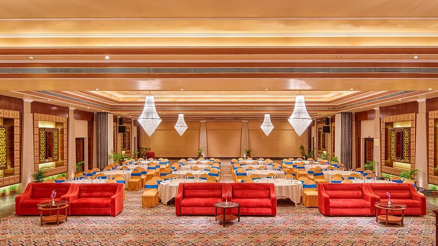 Well-lit banquet hall, with comprehensive decorations, ready to host a festive event.