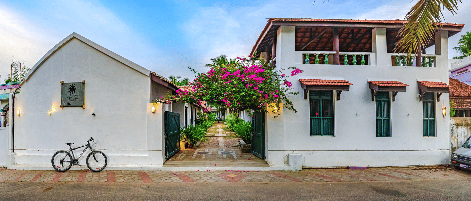 A view of the room cottage exterior with a cycle outside at Neemrana's Coconut Alley - 21st century, Tranquebar, one of the best Tharangambadi hotels.