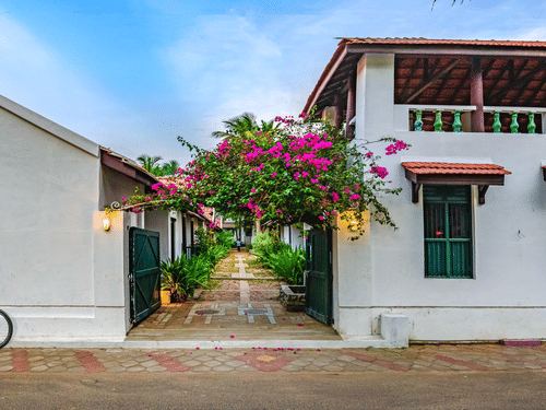 A view of the room cottage exterior with a cycle outside at Neemrana's Coconut Alley - 21st century, Tranquebar, one of the best Tharangambadi hotels.