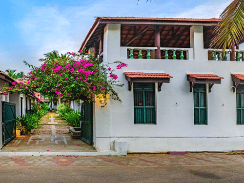 A view of the room cottage exterior with a cycle outside at Neemrana's Coconut Alley - 21st century, Tranquebar, one of the best Tharangambadi hotels.