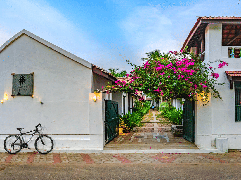 A view of the room cottage exterior with a cycle outside at Neemrana's Coconut Alley - 21st century, Tranquebar, one of the best Tharangambadi hotels.
