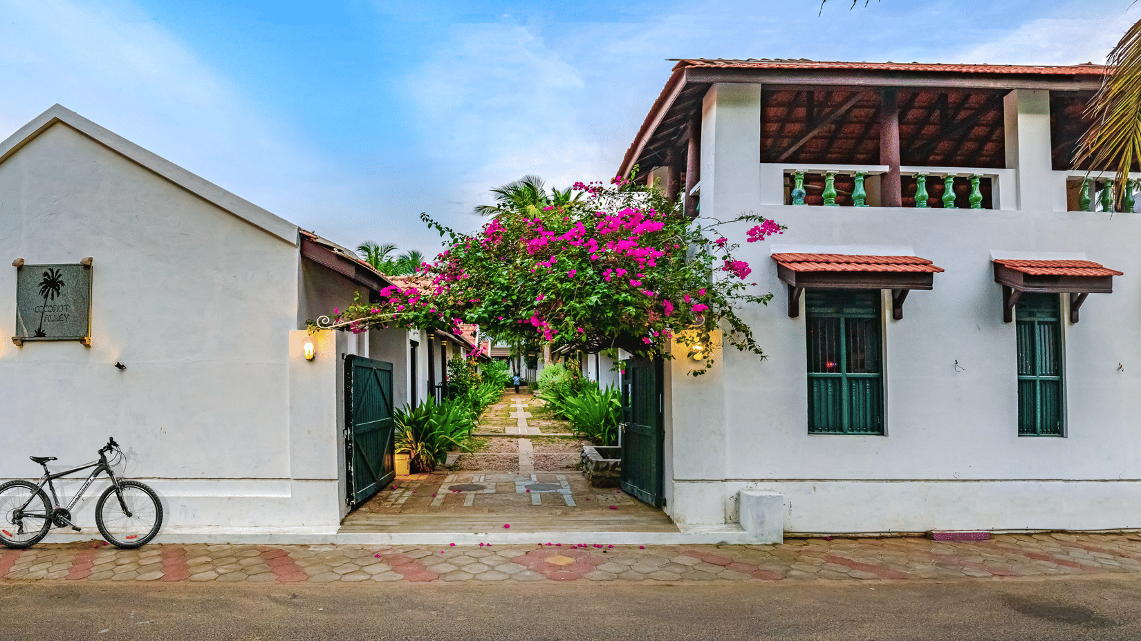 A view of the room cottage exterior with a cycle outside at Neemrana's Coconut Alley - 21st century, Tranquebar, one of the best Tharangambadi hotels.