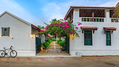 A view of the room cottage exterior with a cycle outside at Neemrana's Coconut Alley - 21st century, Tranquebar, one of the best Tharangambadi hotels.