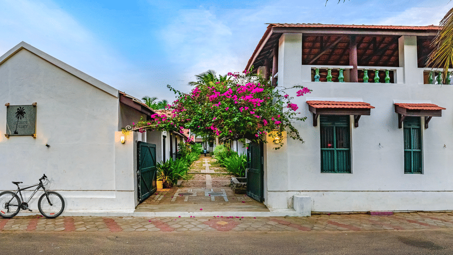 A view of the room cottage exterior with a cycle outside at Neemrana's Coconut Alley - 21st century, Tranquebar, one of the best Tharangambadi hotels.
