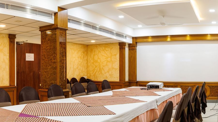 A side angle Image of a hall, with the Table and chairs arranged and beautifully lit.