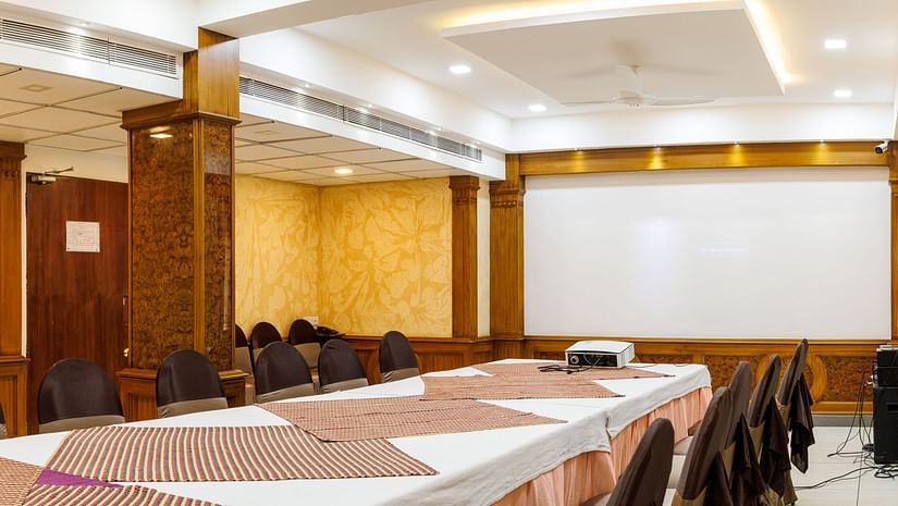 A side angle Image of a hall, with the Table and chairs arranged and beautifully lit.