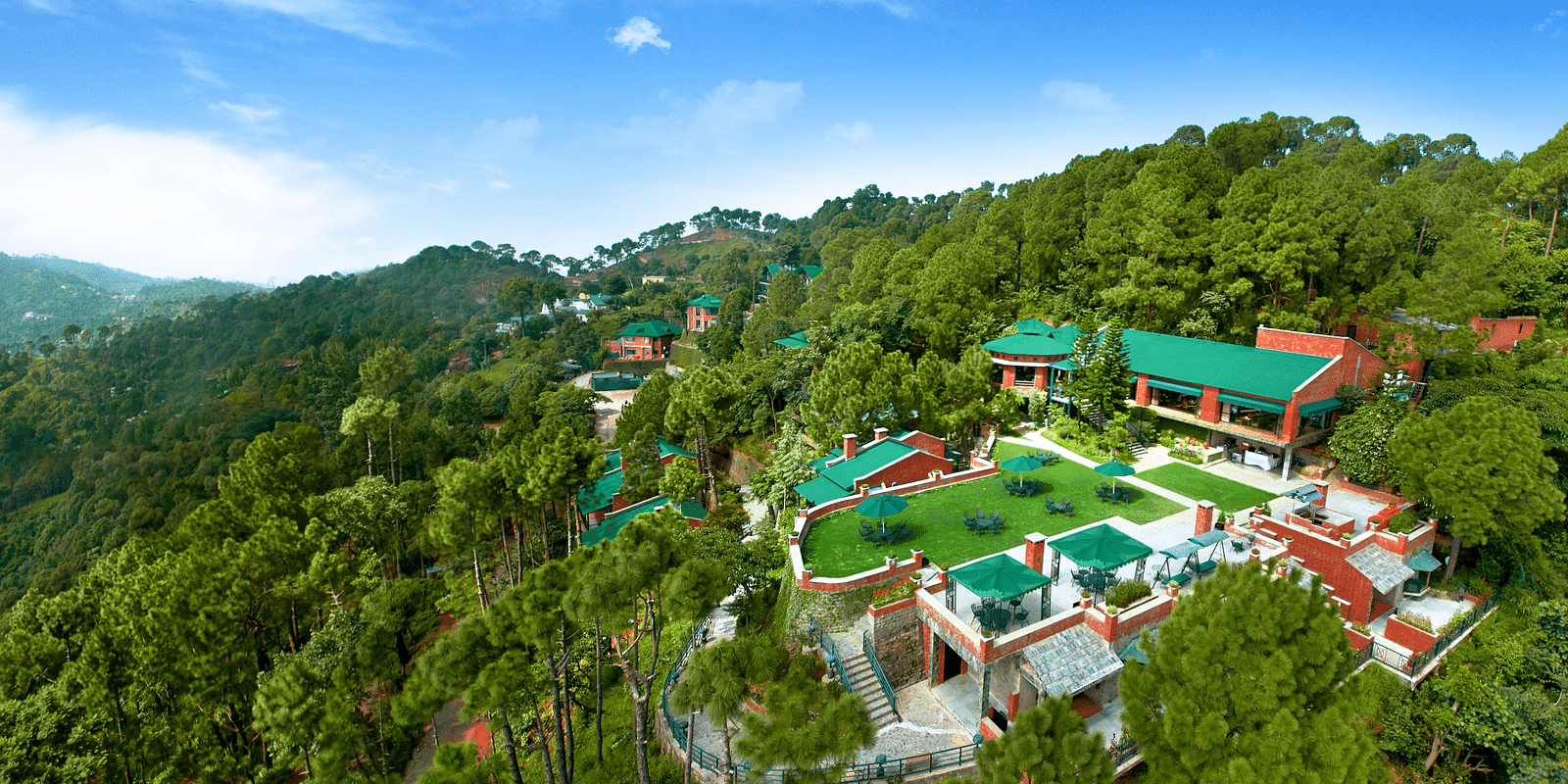 An aerial view of a resort located on top of a mountain near Kasauli, bathed in daylight