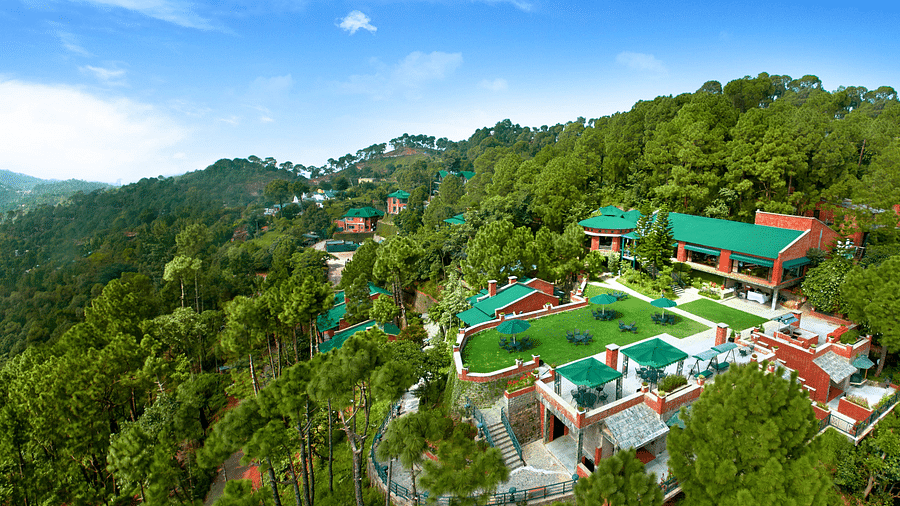 An aerial view of a resort located on top of a mountain near Kasauli, bathed in daylight