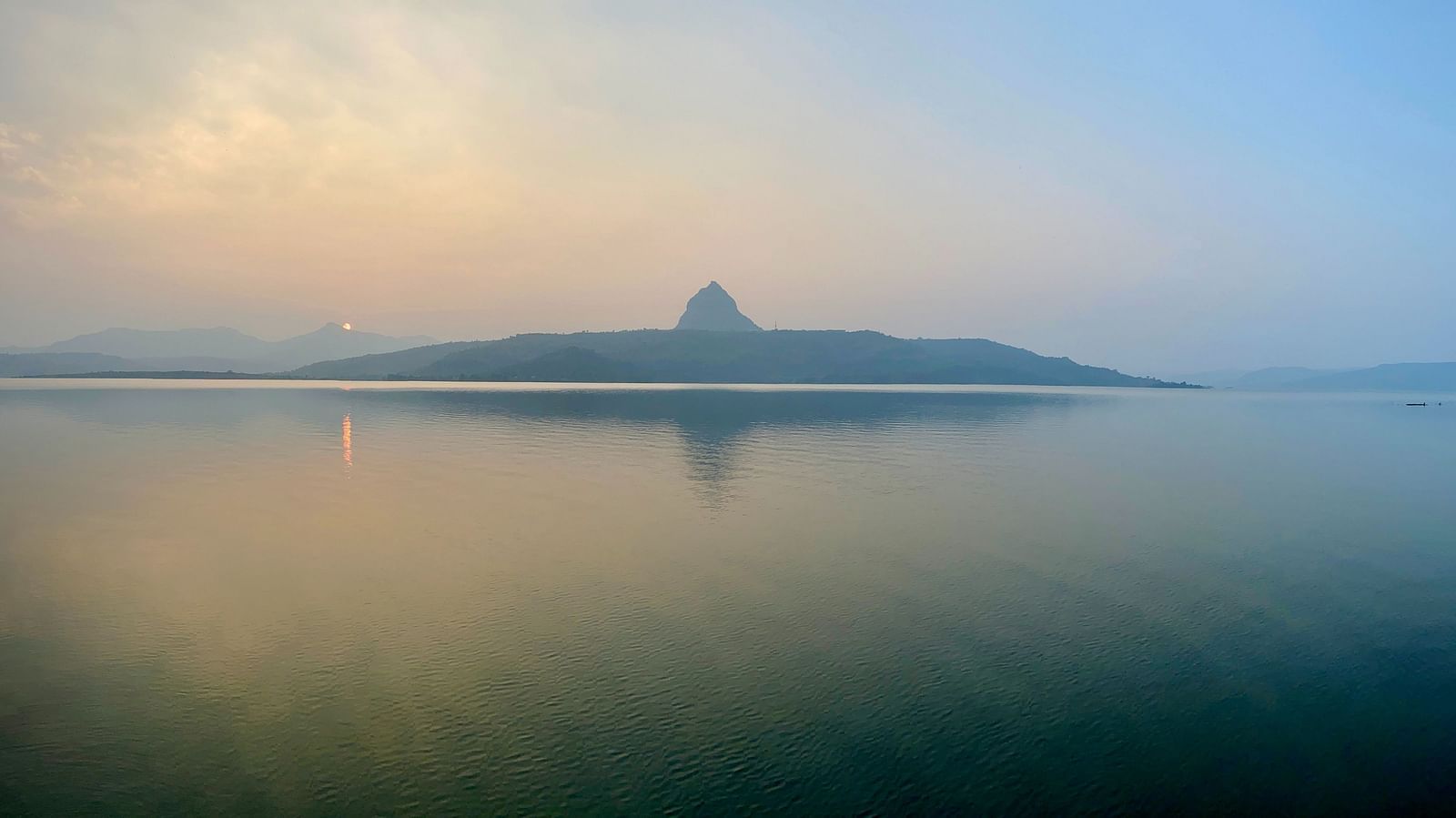 The calming blue hue of the Pawna lake blends into the sky above