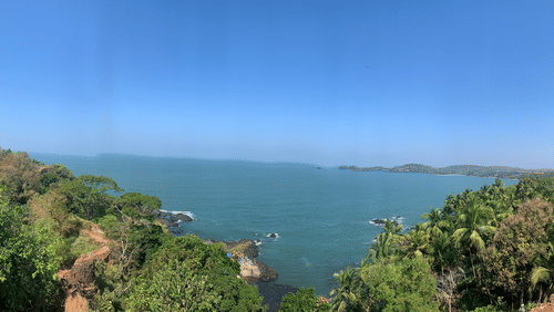 A panoramic view from the Cabo Da Rama Fort into the Arabian Sea with blue sky in the background.