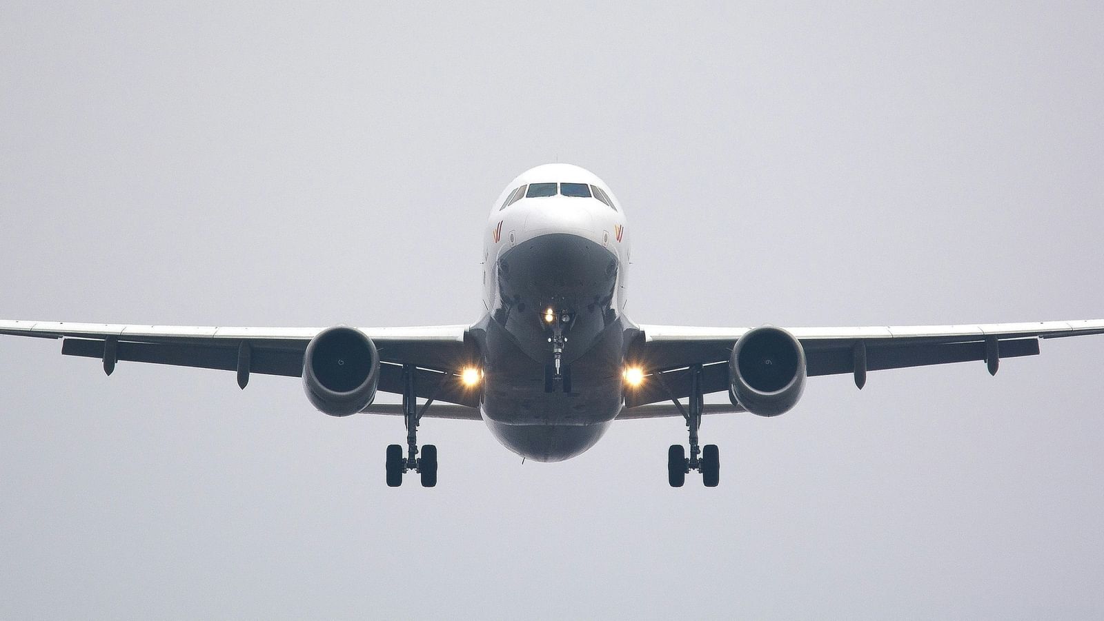 A white airplane flying low in the sky