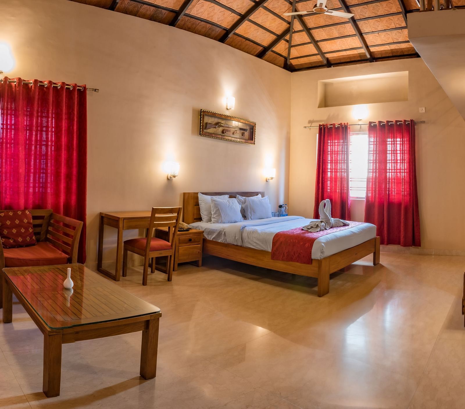 A wide-angle view captures the entirety of Attic Villa, showcasing the bed, seating area, and overall layout | Woodstock Resorts, Coorg