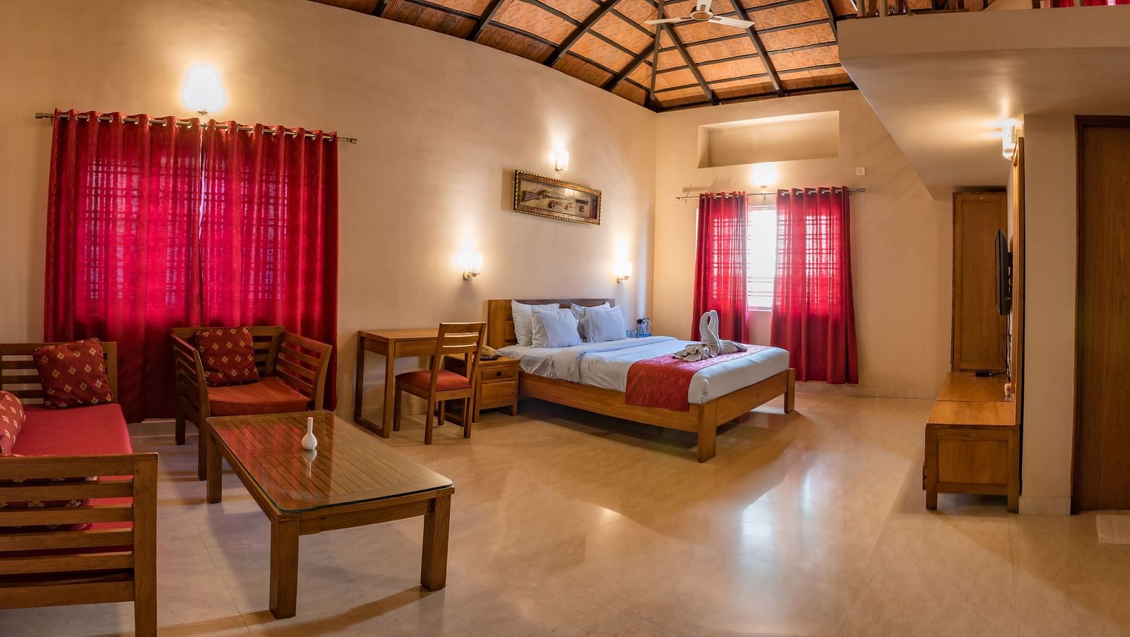 A wide-angle view captures the entirety of Attic Villa, showcasing the bed, seating area, and overall layout | Woodstock Resorts, Coorg