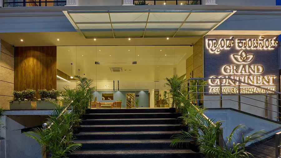 A facade image of the hotel with an illuminated signboard indicating the name of the hotel