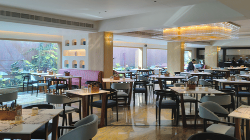 Different types of seating arrangements in a dining space at The Wild Fork restaurant in La Marvella, Bengaluru. 