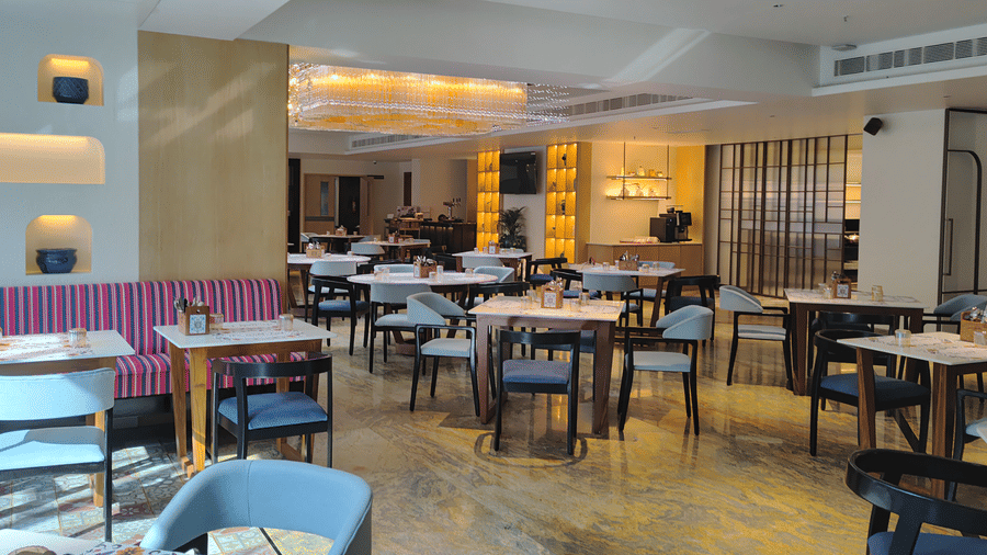 The Wild Fork restaurant featuring sofa chairs, chairs, and dining tables with cutlery and placed at La Marvella, Bengaluru