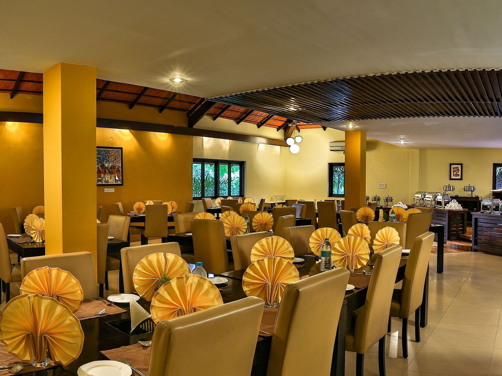 image of a restaurant with clusters of tables scattered - Kadkani River Resort, Coorg