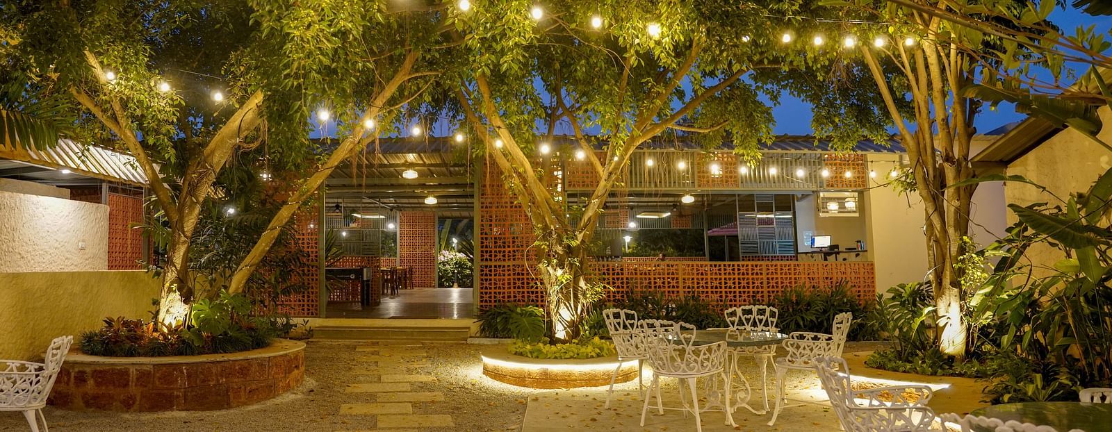 An image a restaurant with outdoor seating, bright lighting, greenery and decoration - Trance Veechika Resort