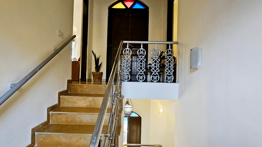 Staircase leading to the upper level with a wooden door in front of it at Amara Villa. Nagoa.