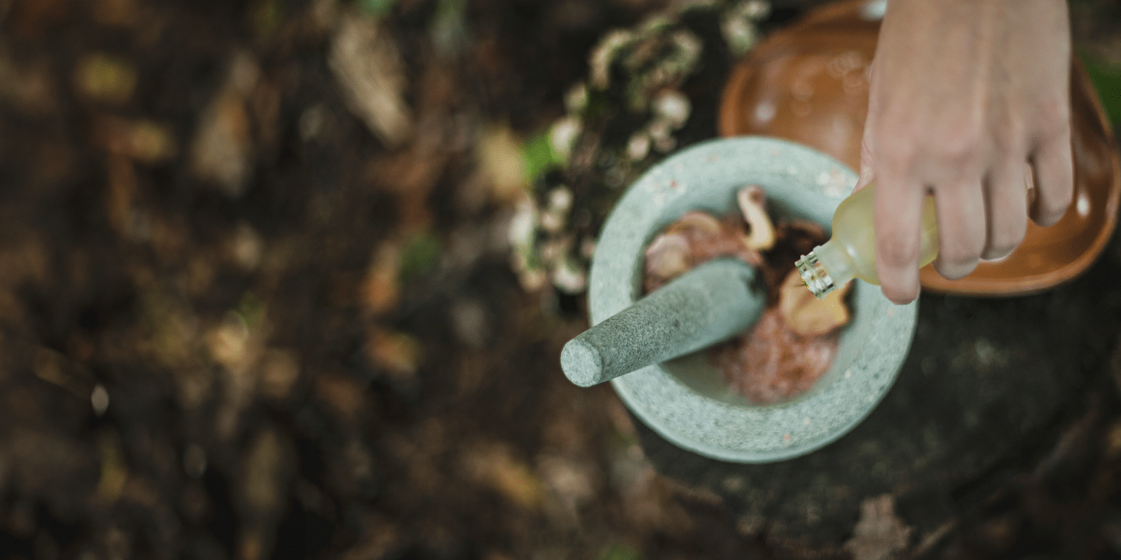 a person pouring a liquid into a mortar