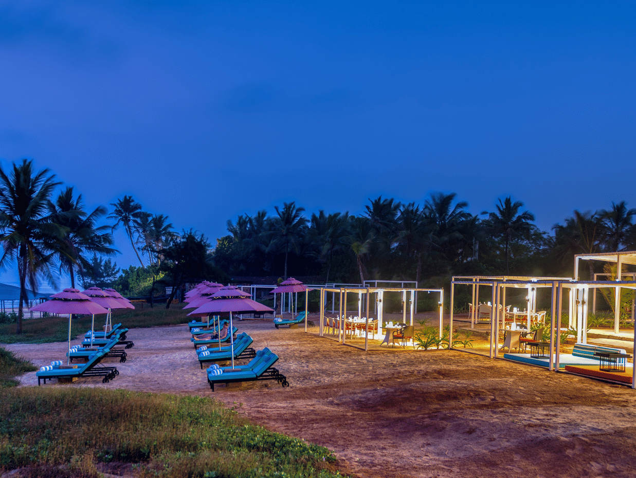 A view of Benaulim Beach after sunset with lounge chairs and cabana set up on the shoreline at Blue Iris Restaurant at Azaya Beach Resort, Goa.
