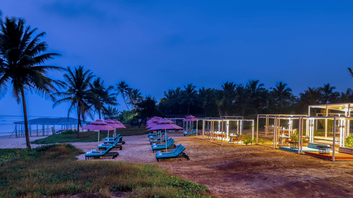Benaulim beach after sunset with lounge chairs and cabana set up - Azaya Beach Resort Goa