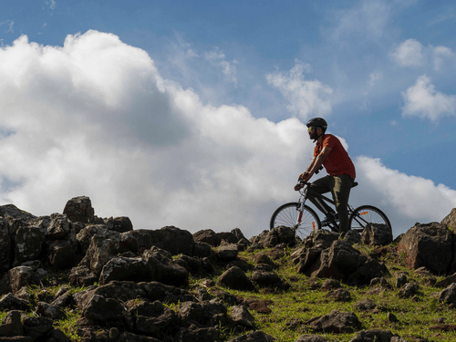 person riding a bicycle over rocks