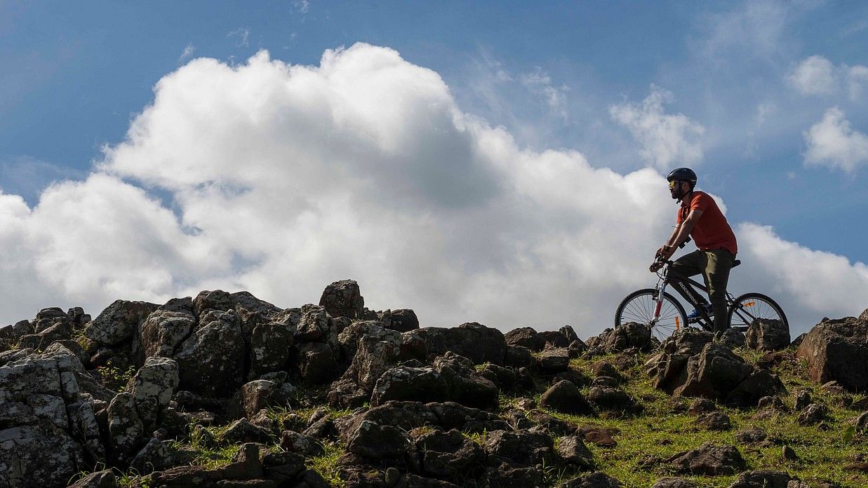 person riding a bicycle over rocks