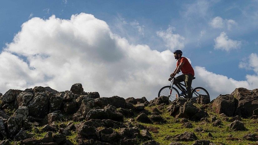 person riding a bicycle over rocks