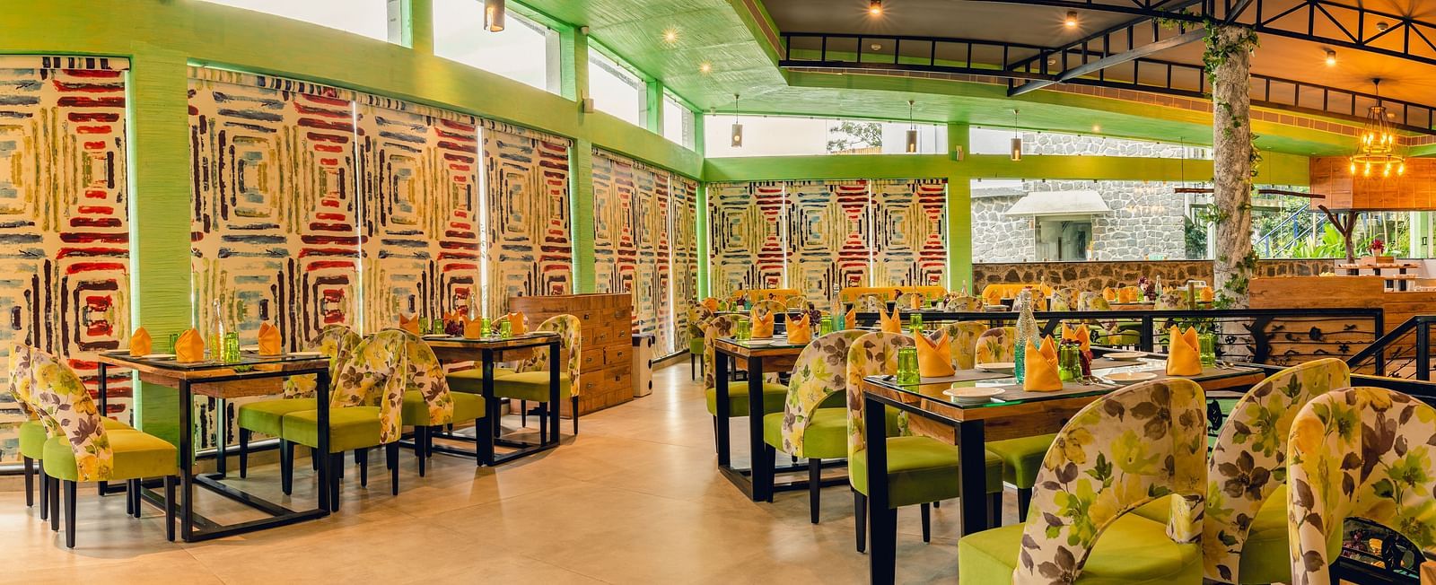 An image of a restaurant with different seating arrangement, bright lighting, and decorative items - Great Trails Yercaud by GRT Hotels