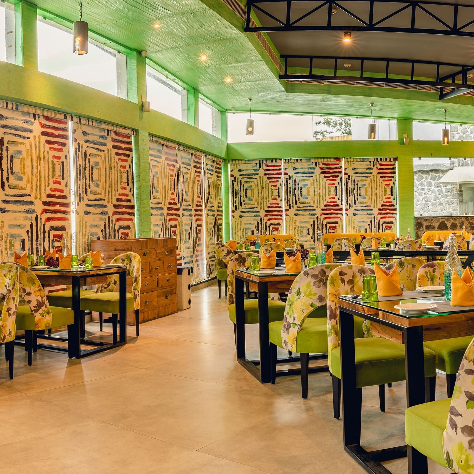 An image of a restaurant with different seating arrangement, bright lighting, and decorative items - Great Trails Yercaud by GRT Hotels