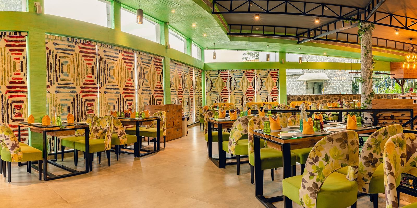 An image of a restaurant with different seating arrangement, bright lighting, and decorative items - Great Trails Yercaud by GRT Hotels