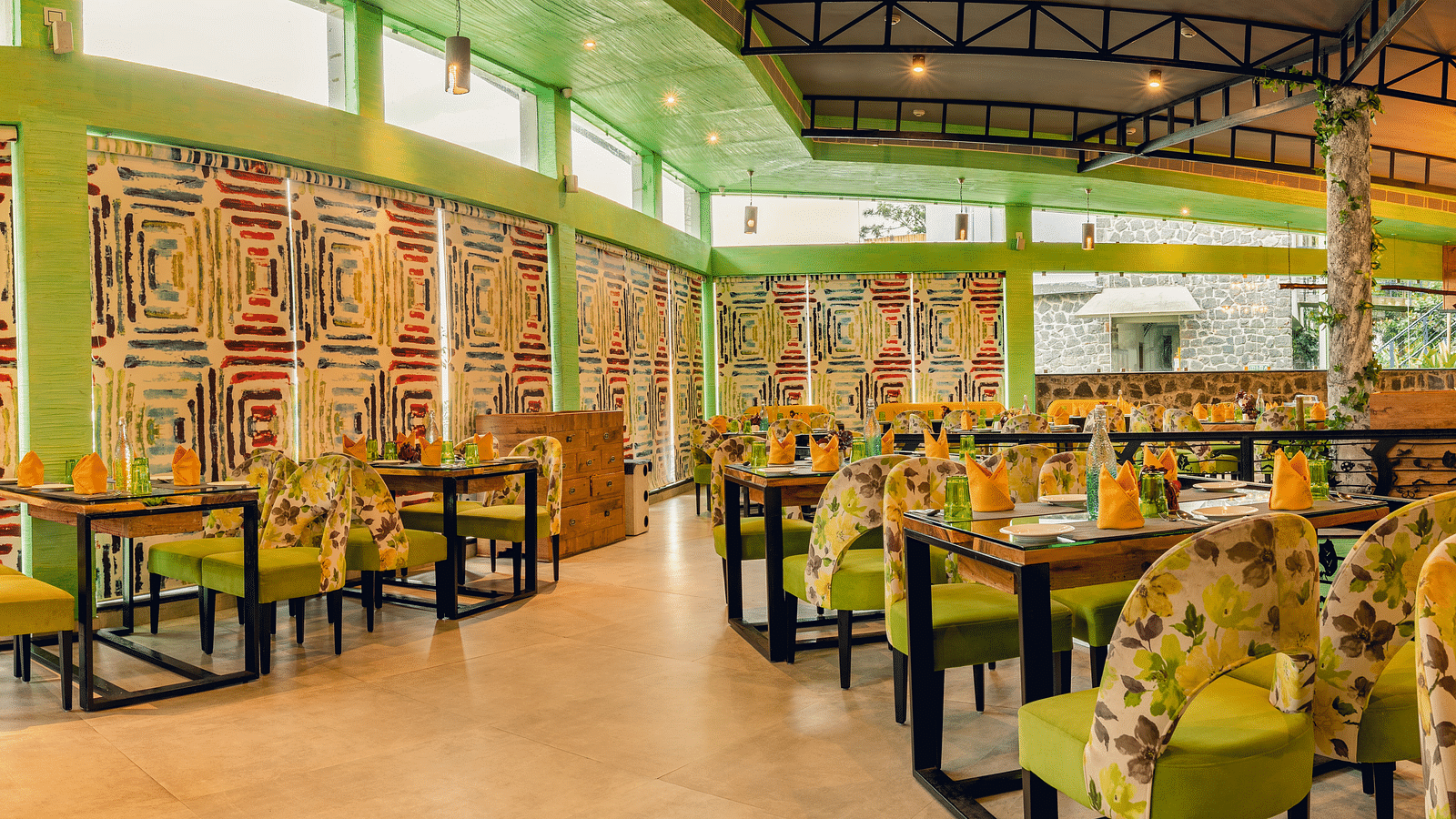 An image of a restaurant with different seating arrangement, bright lighting, and decorative items - Great Trails Yercaud by GRT Hotels