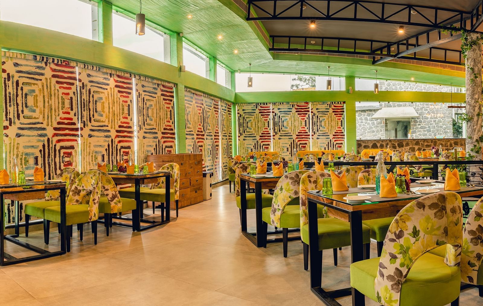 An image of a restaurant with different seating arrangement, bright lighting, and decorative items - Great Trails Yercaud by GRT Hotels