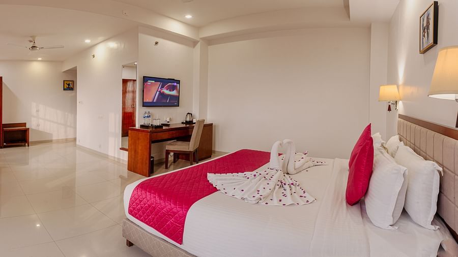 Bright and airy hotel room at Diamond Palace Lords Plaza with a double bed, work desk, and separate seating area.
