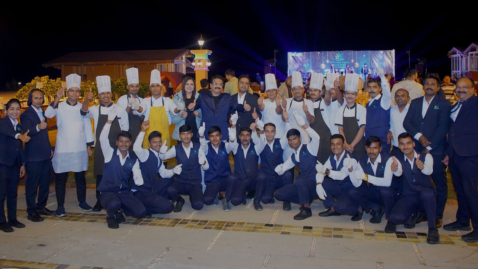 Staff members, including chefs and service team, posing at an outdoor gathering - The Grand Legacy Resort & Spa