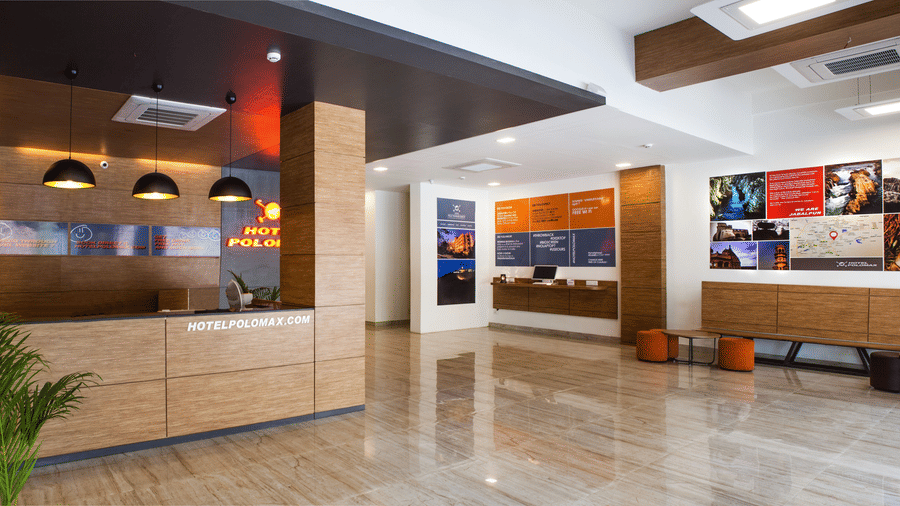 An image of a reception lobby featuring a reception desk , and a seating area for the guest - Max Hotel Jabalpur