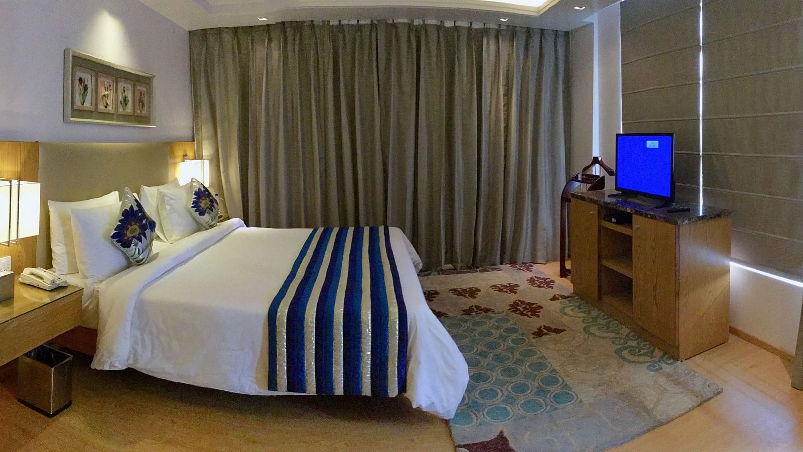 A bedroom featuring a double bed with a television kept in front of it - Ramada by Wyndham, Ghaziabad, Vasundhara