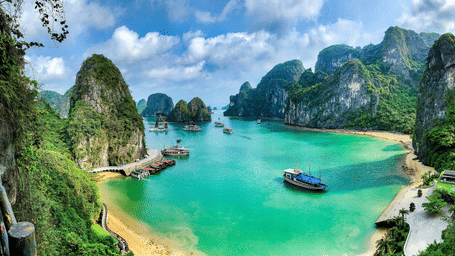 An aerial view of Ha Long Bay with many mountains on the waterbody with beaches and boats also in view as seen during day time
