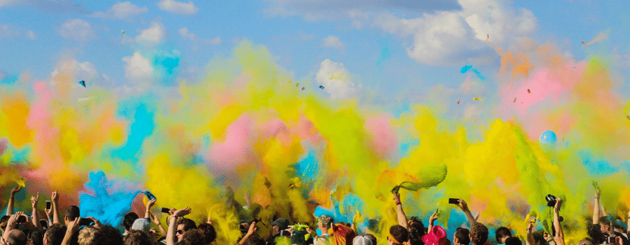 an image of people dancing during daytime with colours floating in the air