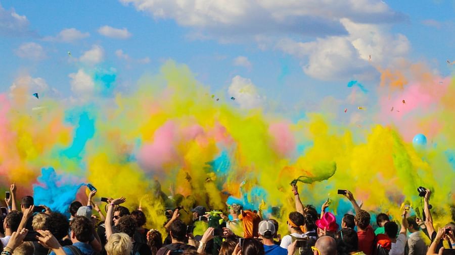 A crowd throws colours in the air for Holi