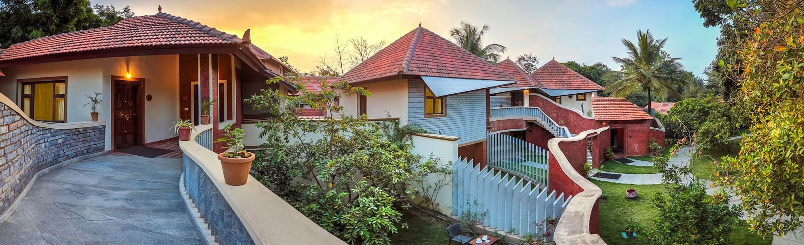 facade image of the luxury jucuzzi villas with an amazing sunset in the background at hoysala village resort in hassan.