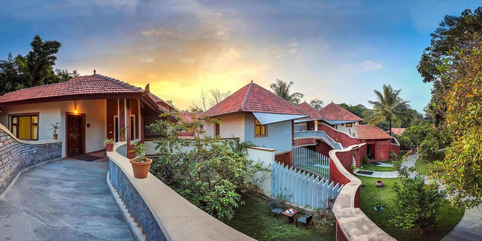 facade image of the luxury jucuzzi villas with an amazing sunset in the background at hoysala village resort in hassan.