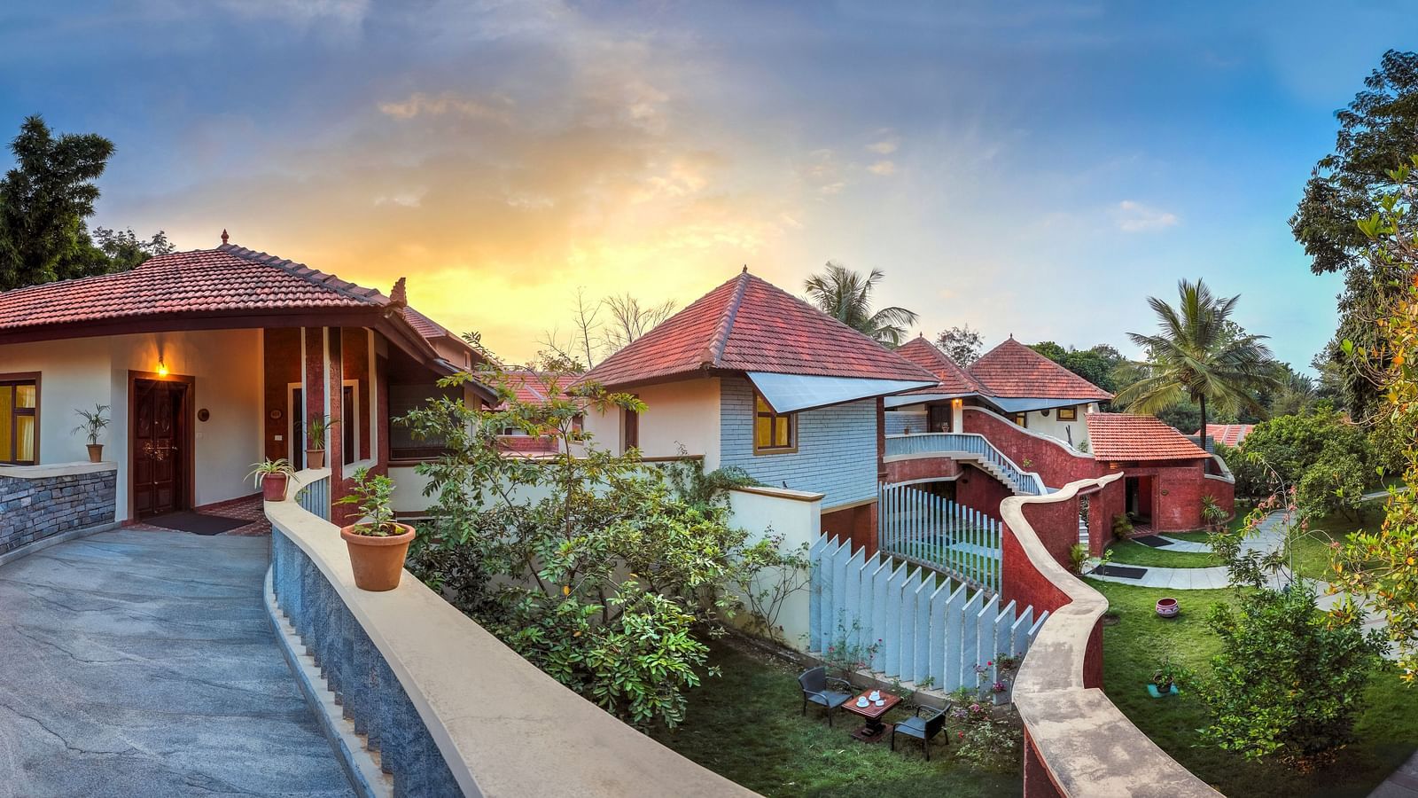 facade image of the luxury jucuzzi villas with an amazing sunset in the background at hoysala village resort in hassan.