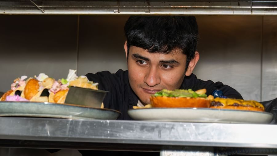 Chef presenting completed dishes ready to be served from the kitchen window at Narrow Gauge Inn.